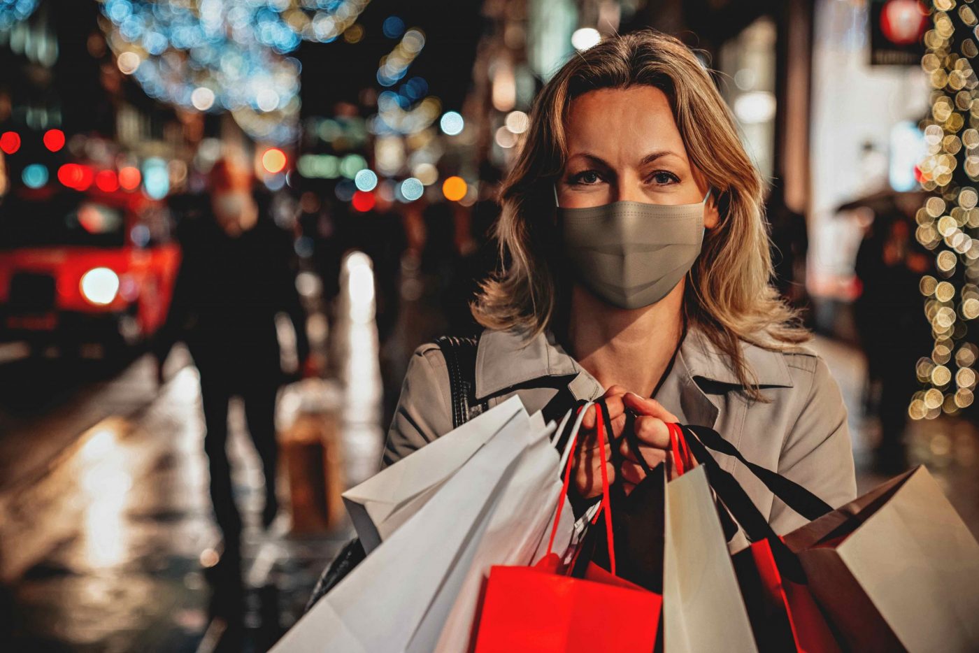 Portrait of a woman wearing a facemask while Christmas shopping and holding bags â COVID-19 pandemic lifestyle concepts